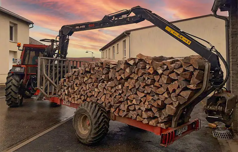 tracteur avec bras mécanique et remorque de bois